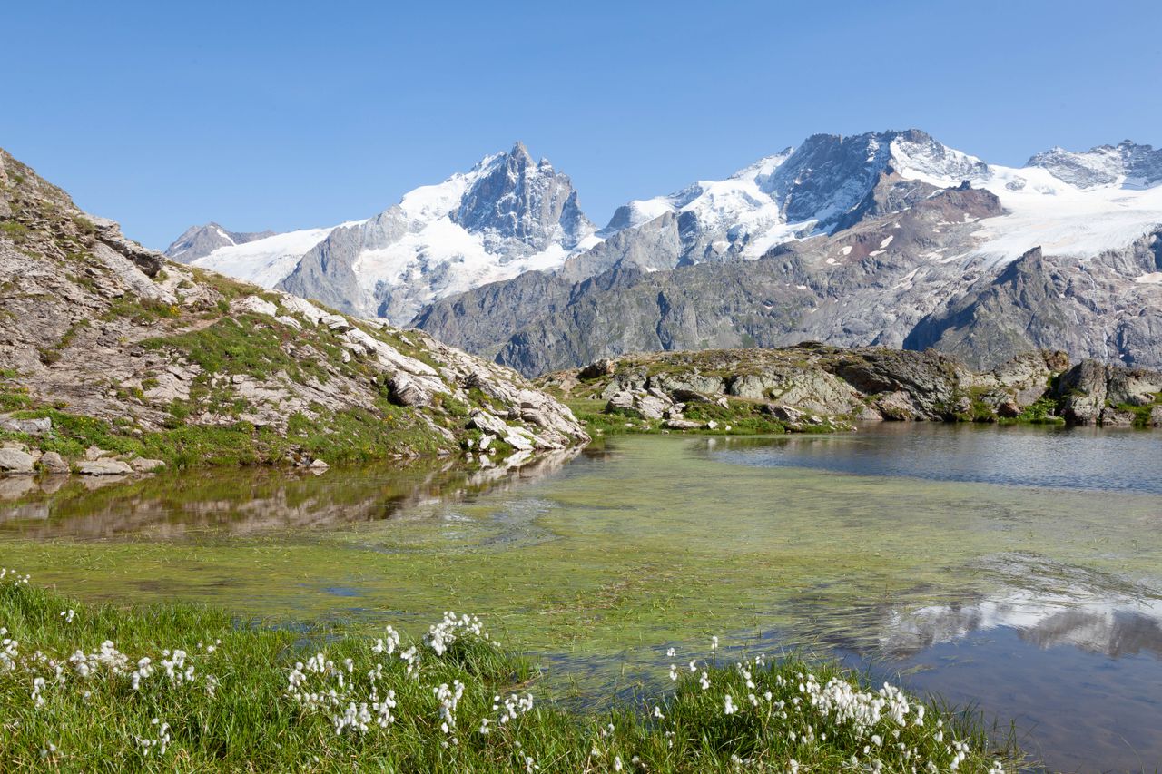 Picturesque view of snowcapped mountains and serene lake at La Grave, France.