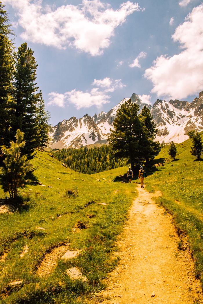 Explore the serene hiking trails of Ceillac, France, with scenic views of snow-capped mountains.